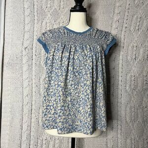 Anthropologie blue floral top with ruched sleeves and elastic neckline.